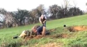 Terrierman Alex Warden (in blue jumper) retrieves his terrier from the dug out badger sett as fiance Melissa Hyde leans over.